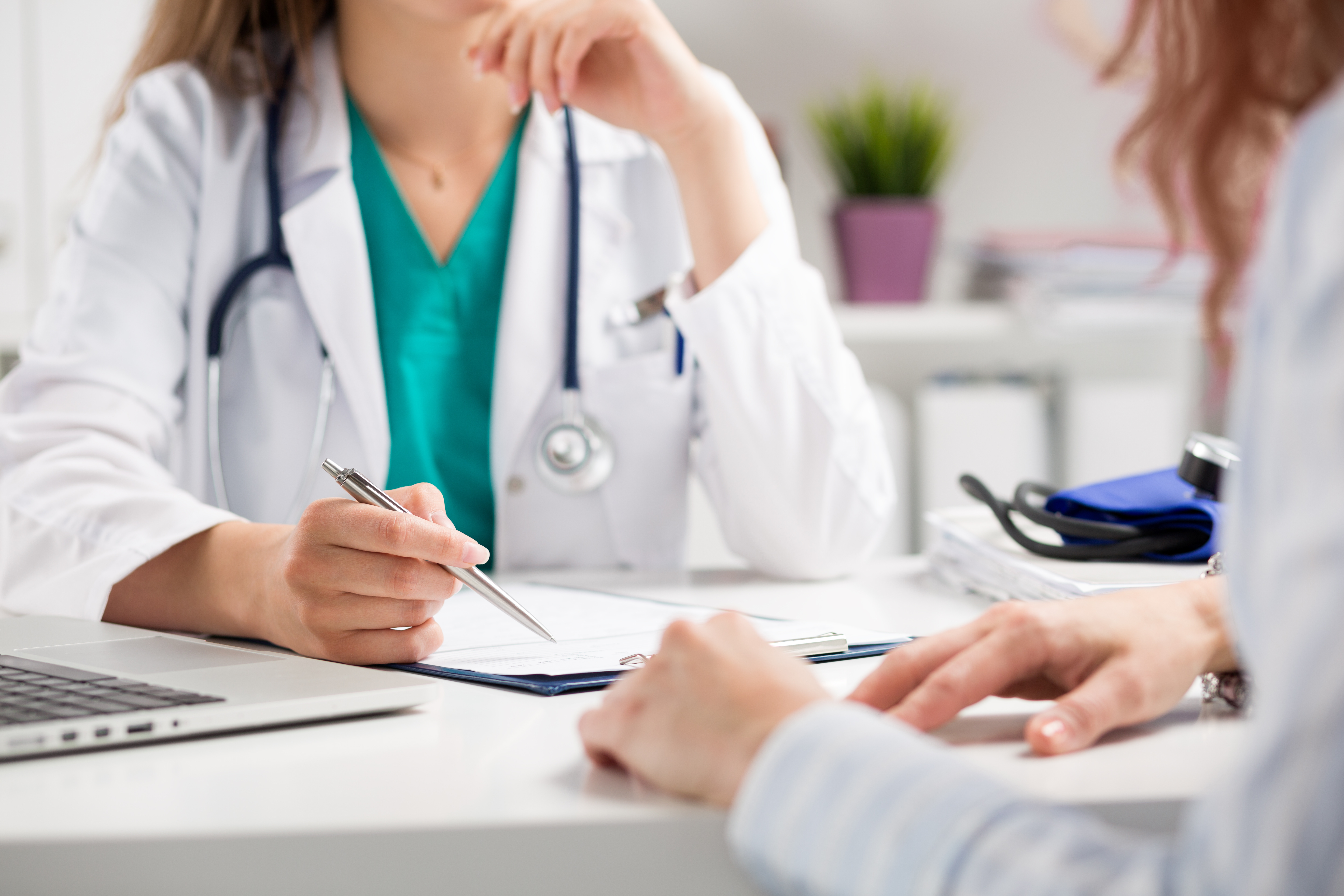 Doctor with face obscured speaks with a patient