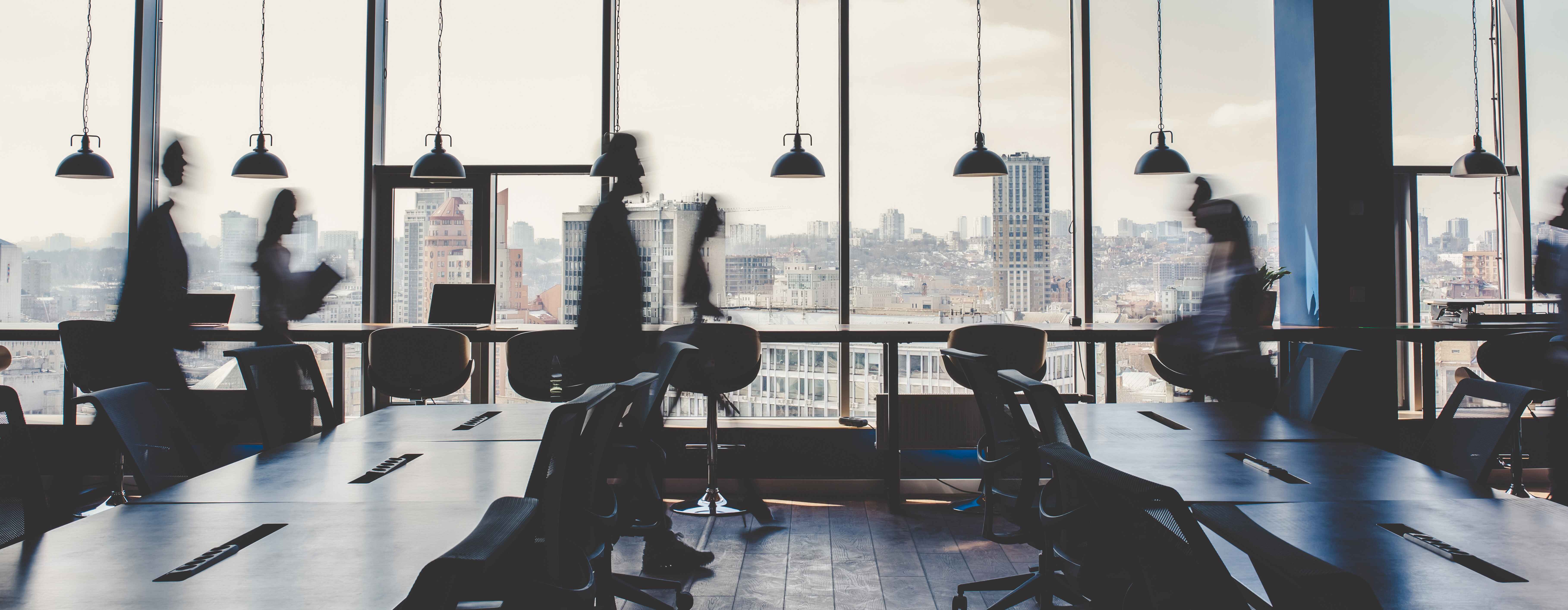 Modern office with workstations, large windows, and a city view.