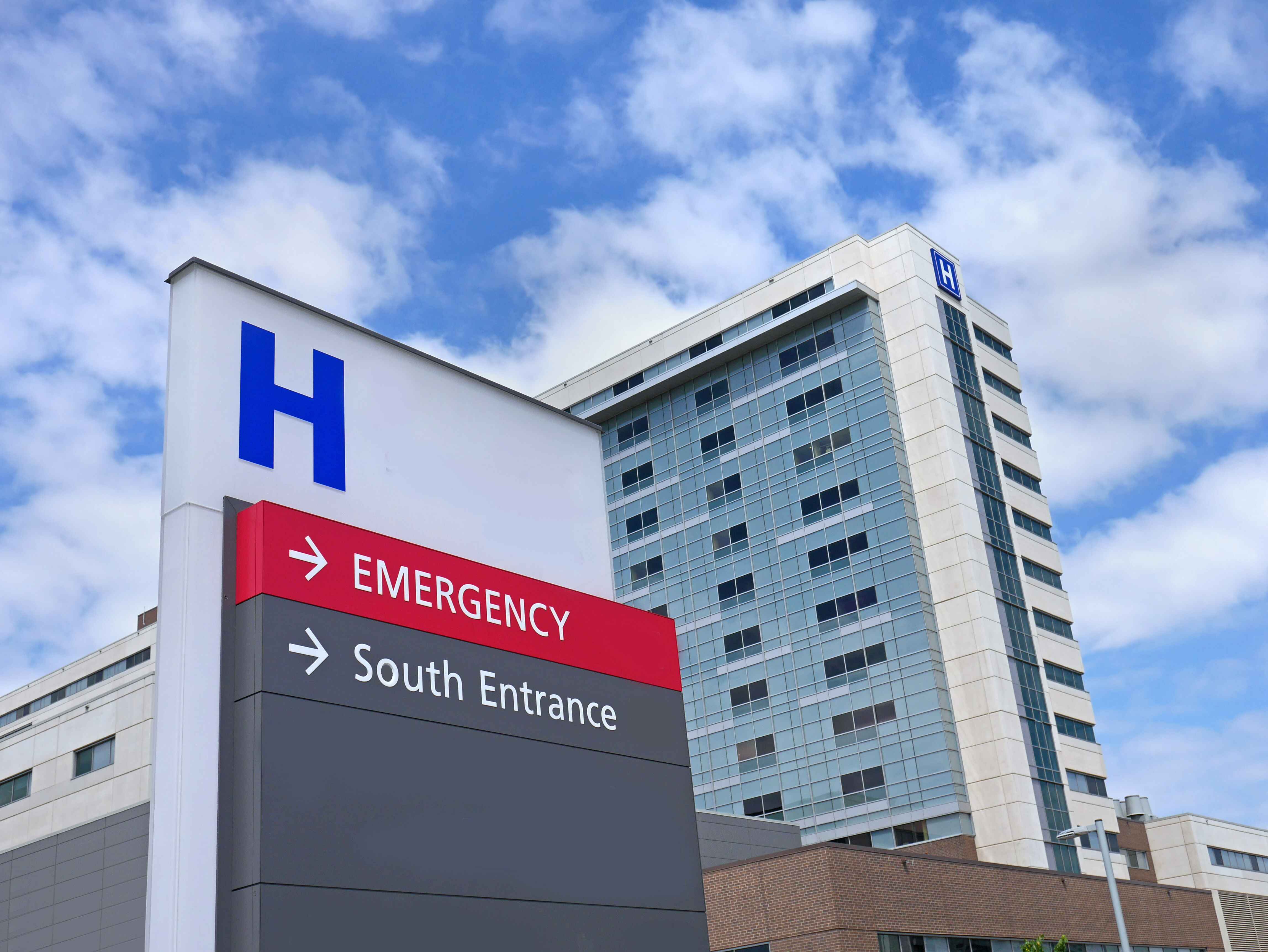 Modern hospital building with emergency entrance sign.