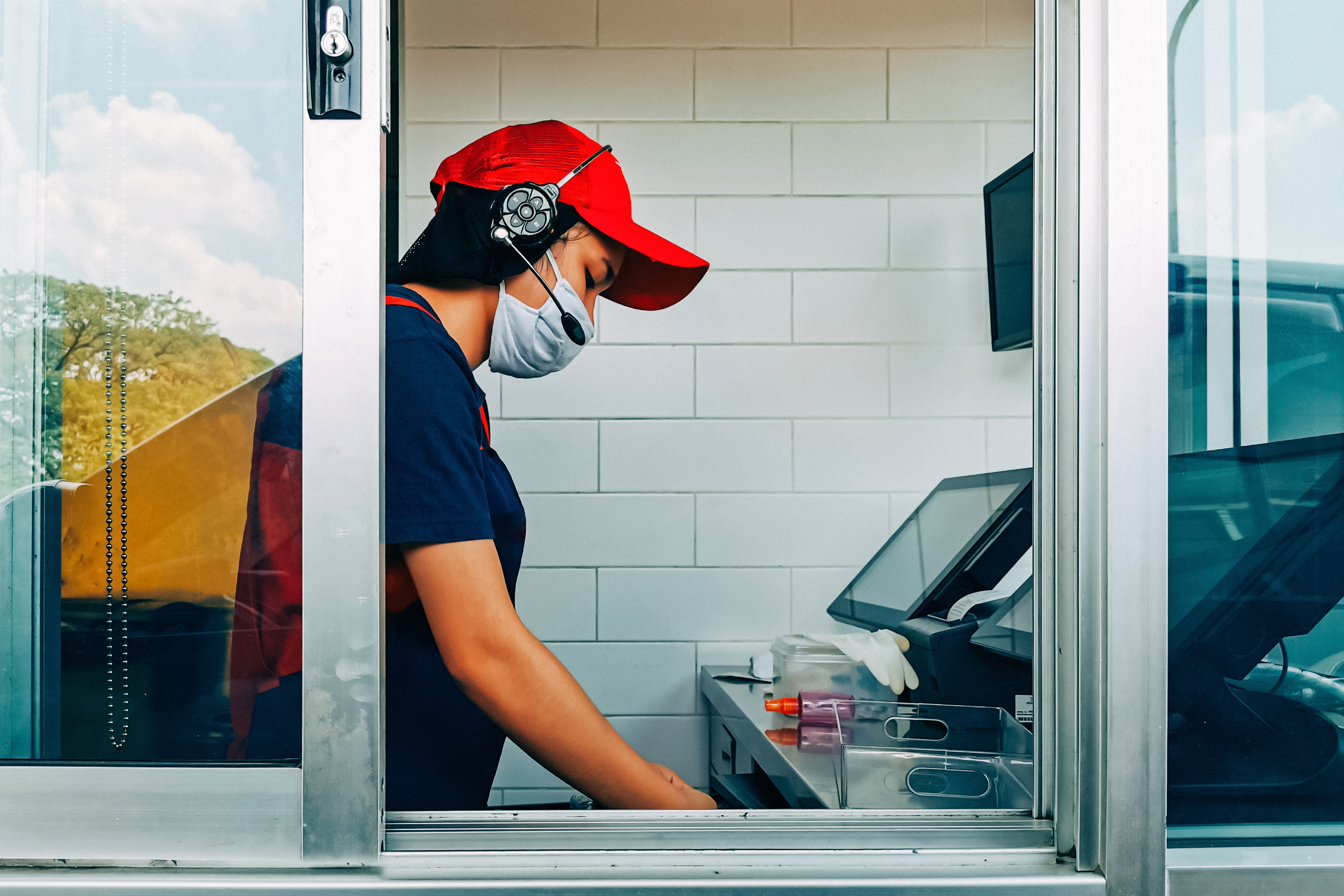 A fast food worker in a drive through window