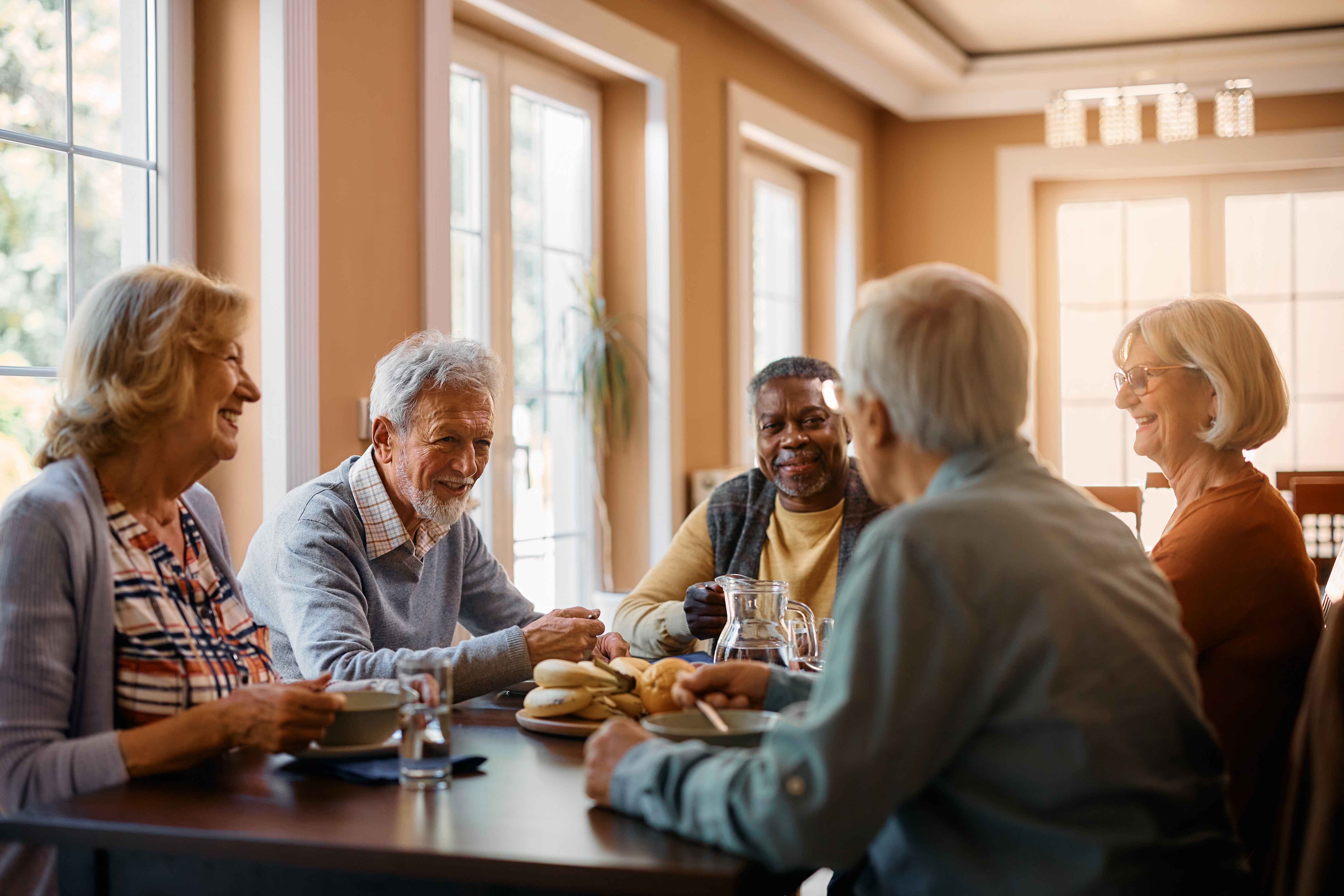 Elderly sitting around a sunlight table.