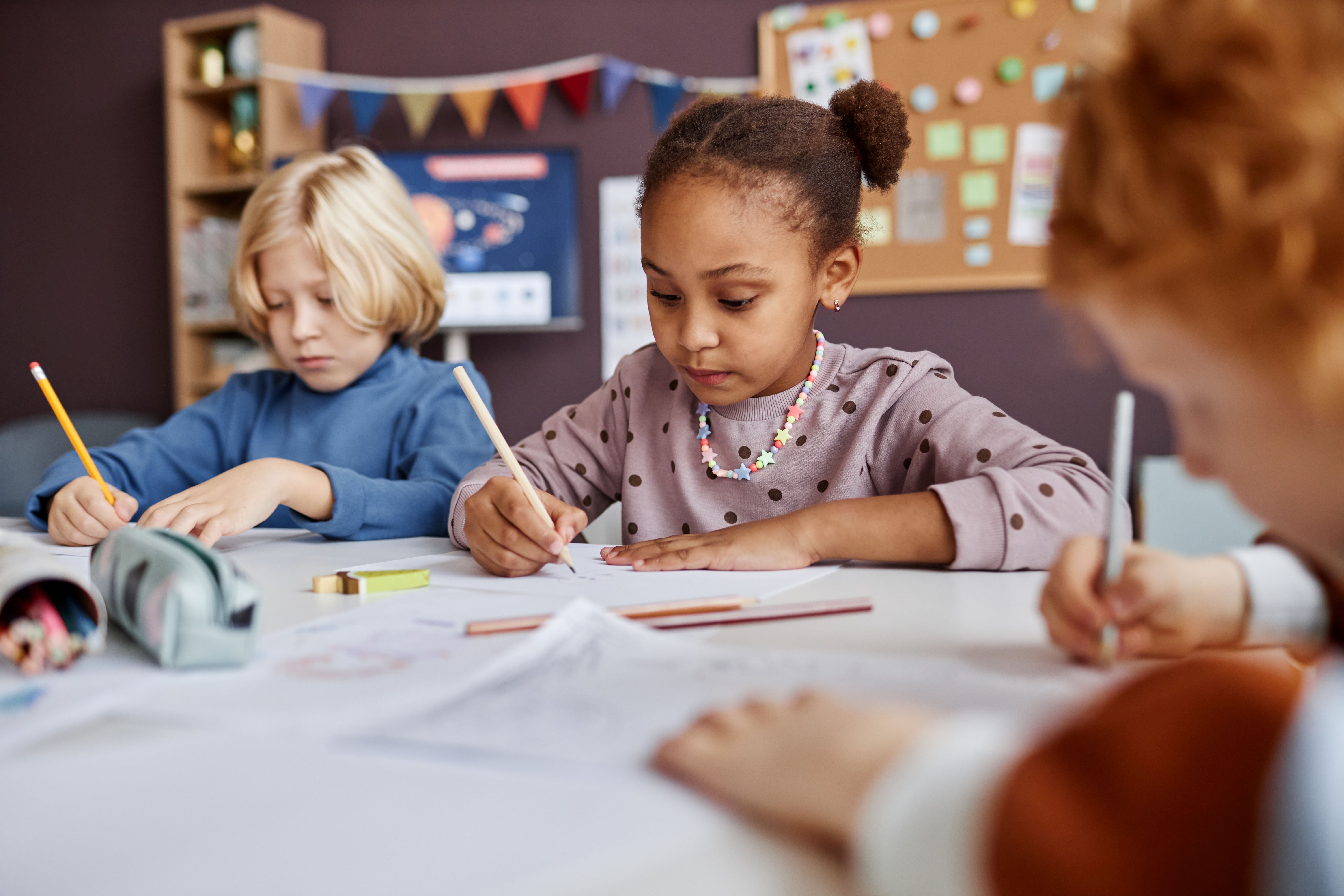 Children writing at a desk