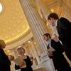 Four people standing and speaking to each other under a rotunda