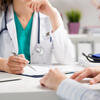 Doctor with face obscured speaks with a patient