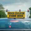 Roof of a car with yellow sign reading Driver Education Student Driver