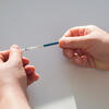 Twin white skinned hands hold a test strip