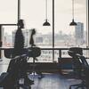 Modern office with workstations, large windows, and a city view.