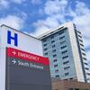 Modern hospital building with emergency entrance sign.