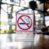 Sign on a table with a cigarette in a slashed red circle 
