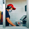 A fast food worker in a drive through window