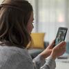 Woman video calling on her smartphone while sitting indoors.