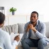 A man in casual attire engaged in conversation during a counseling session.