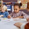 Children writing at a desk