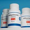 Three bottles of Mifepristone Tablets against a blue background.