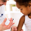 Male doctor gives injection vaccination to young girl