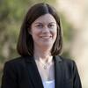 White woman in a black blazer outside 