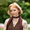 White woman standing outside wearing brown